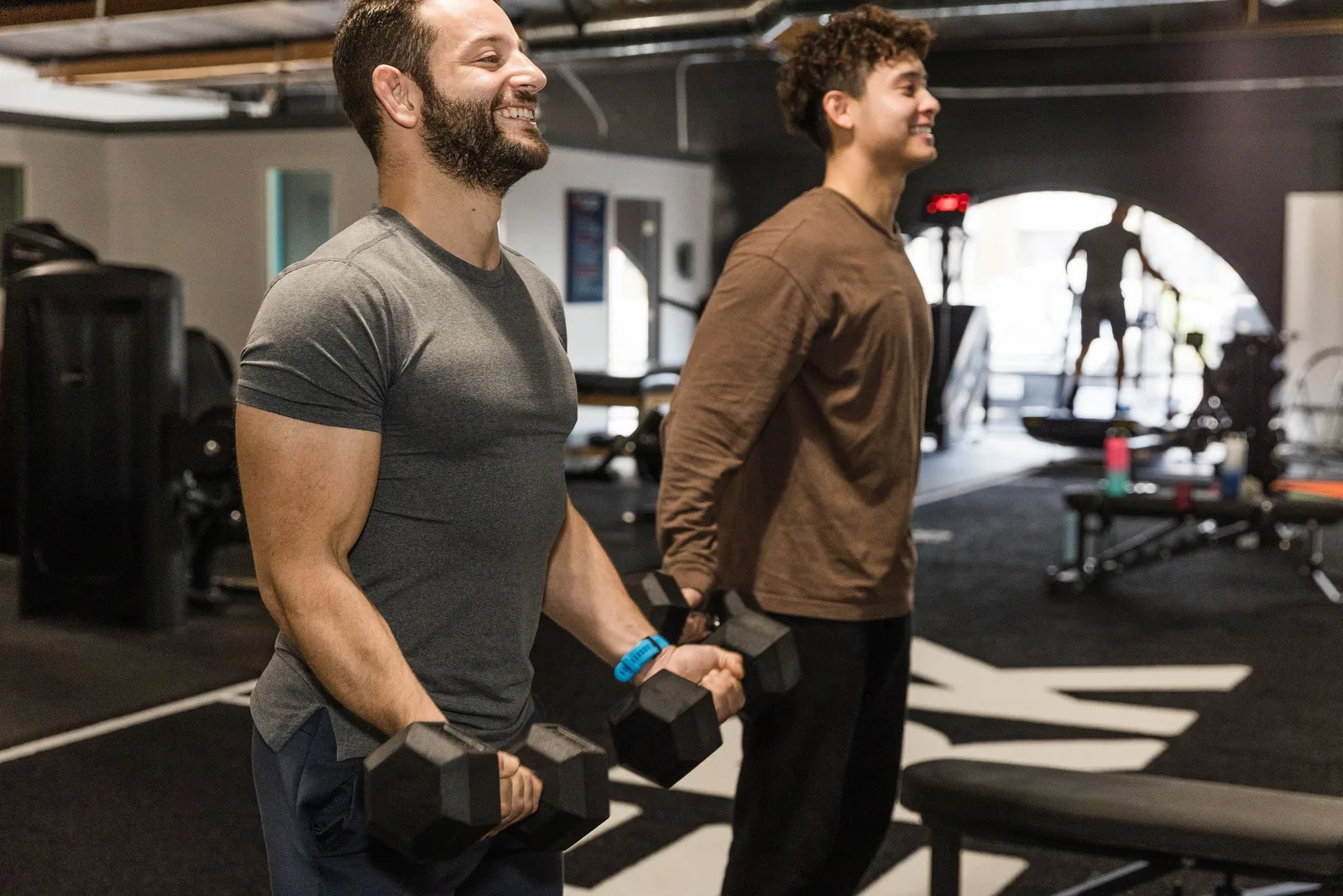 Nemezio LopezPerez coaching a client through dumbbell curls side by side during a 1:1 session